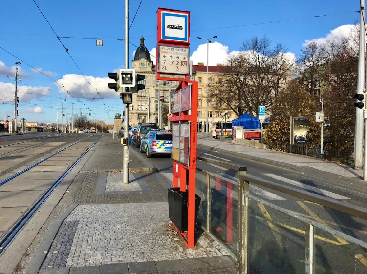 The original, red tram sign on the waterfront side of Palackého náměstí.  He will probably soon replace the more modern ones.